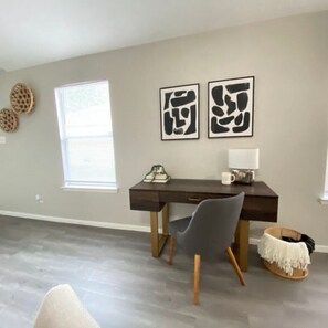 Stay productive in this work corner, featuring a window and beautiful paintings