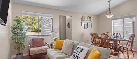 Living room with dining room view. The sofa converts into a bed.