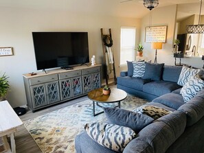 Cozy living room with lots of seating on the sectional couch, plenty of pillows and extra blankets to relax and watch tv or play a board game! 