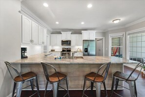 GIANT kitchen with gorgeous counters and seating.