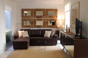 Living room, with a sofa, a television and design furniture and decoration.
