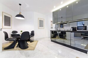 Fully equipped kitchen next to the dining table, with four seats.