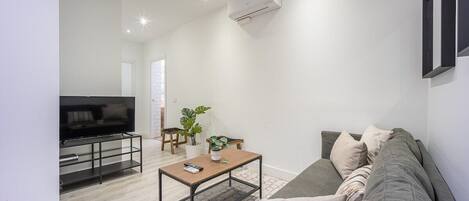 View of the living room with sofa, side table and TV