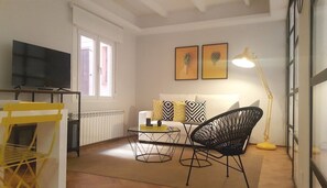 General view of the living-dining room with exterior window and TV