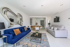 Main view of the living-dining room space and the kitchen in the background