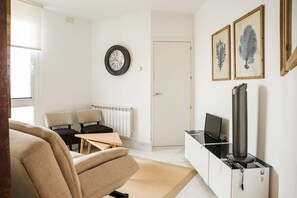 View of the living room, with design furniture and a television.