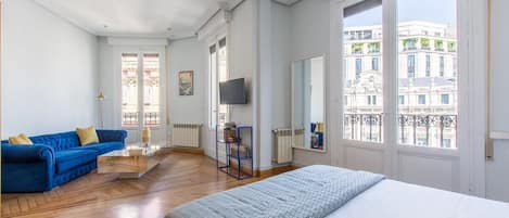 Dormitorio 2, con cama de matrimonio doble, sala de estar con televisión y vistas a La Plaza de Canalejas.