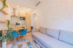 General view of the living room with kitchen in the background