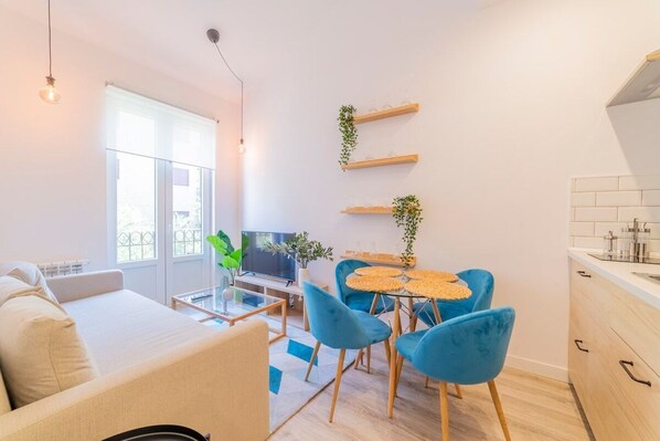 General view of the living room with kitchen in the background and access to the balcony