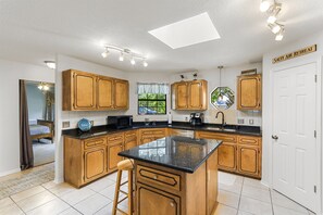 Full kitchen with three bar stools