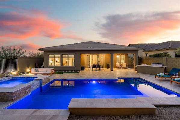 Backyard Oasis | Gas-Heated Pool, Hot Tub & Putting Green Relax in your private outdoor retreat featuring a heated pool, hot tub, and putting green, all with stunning desert sunset views.