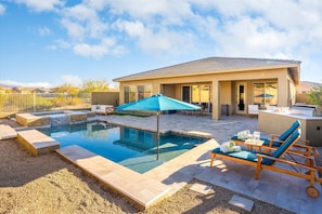 Backyard Paradise | Gas-Heated Pool, Hot Tub & Lounge Area Soak up the Arizona sun with poolside loungers, a shaded umbrella, and a relaxing hot tub, all in your private desert retreat.