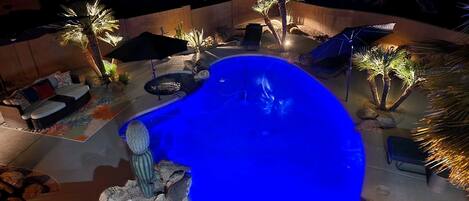 Hot tub and pool lit up for nighttime enjoyment