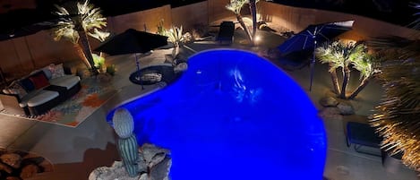 Hot tub and pool lit up for nighttime enjoyment