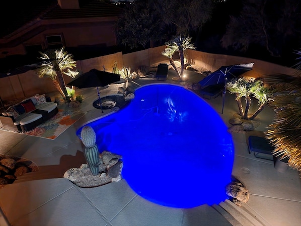 Hot tub and pool lit up for nighttime enjoyment
