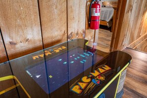 In the loft of our cabin, an old-school arcade machine stands out as the centerpiece. With bright flashing lights and colorful buttons, it beckons you to come and play your favorite games from the past. 