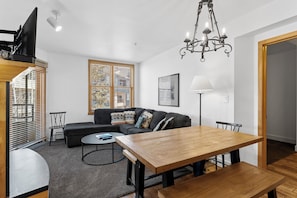 Living area with mounted flat screen TV, queen size sleeper sofa, gas fireplace and access to the private balcony.