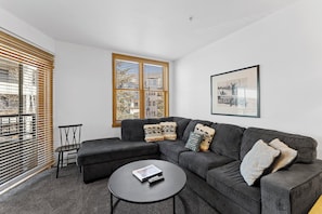 Living area with mounted flat screen TV, queen size sleeper sofa, gas fireplace and access to the private balcony.