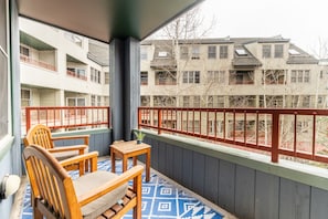 Cozy private balcony overlooking River Run Village with outdoor seating.