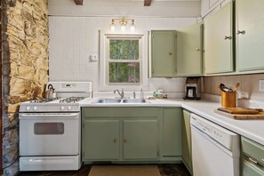 A well-equipped kitchen boasts a dishwasher, gas range, and full-sized fridge.