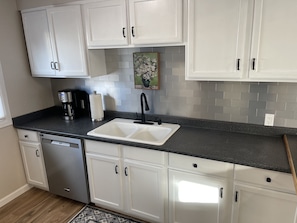 Well stocked kitchen with stainless steel appliances, dishwasher and glass stove
