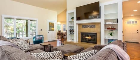 Large airy living room features combination gas/wood burning fireplace