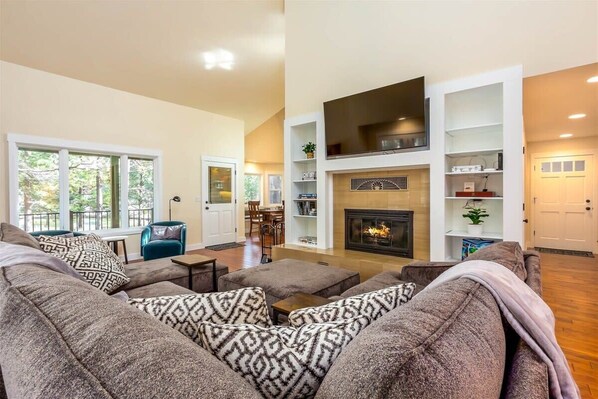 Large airy living room features combination gas/wood burning fireplace