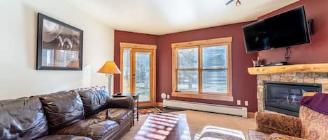 Living area offering cozy furnishings, a gas fireplace, and mounted Smart TV&gt;