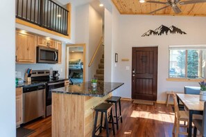 The home has a cheery and bright open floor plan with the living/kitchen/dining area connected together complete with high ceilings and windows all around.