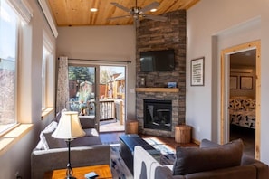 Settle in for a relaxing evening in the cozy living area where you can warm up by the stunning stone fireplace from the couch or chair as you take in the views out the glass sliding doors.