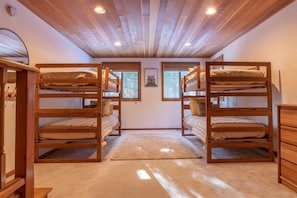 The third bedroom downstairs is a spacious room that is perfect for kids to share with two twin bunk beds, a dresser, and a desk and chair providing another workspace or craft area in the home.