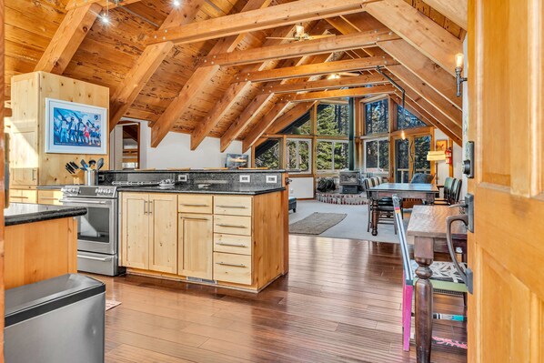 Main Living Space: Open layout, floor-to-ceiling windows, couch, chair, 55” Smart TV, wood-burning fireplace
