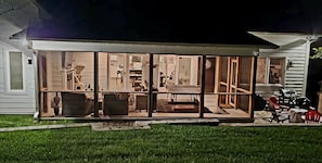 Spacious backyard and night view of screened in porch.