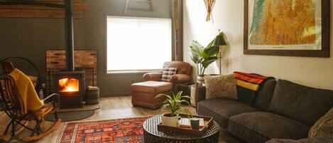 Living Room: Large sectional, oversized leather chair and rocking chair by the wood burning stove.