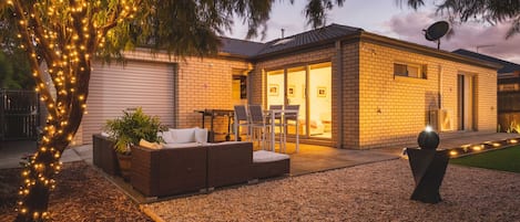 Backyard with patio and bar dining table and flat grill bbq.