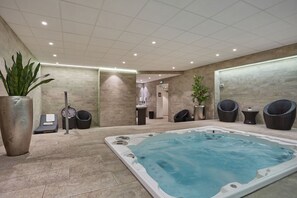 Relaxing shared spa zone with jacuzzi and lounge seating, accessible on-site at the residence.