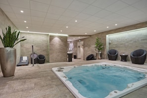 Relaxing shared spa zone with jacuzzi and lounge seating, accessible on-site at the residence.