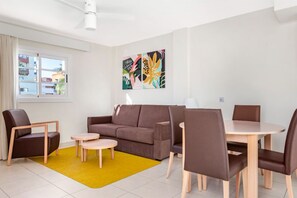 Bright and spacious living area with comfortable seating and a pop of colorful art.