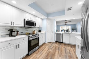 Kitchen features modern appliances, including a full-sized refrigerator, stove, oven, microwave, and dishwasher