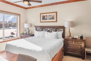 The bedroom is a dynamic space featuring a comfortable king-size bed, a large dresser and desk unit for storage or workspace, and a jacuzzi bathtub for relaxing.