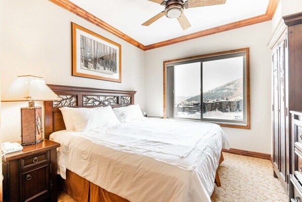 The bedroom provides a comfortable space for a peaceful night of rest with a king-size bed and views overlooking Canyons Ski Resort and the surrounding valley.