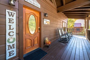 Spacious front porch equipped with six rocking chairs to relax in.