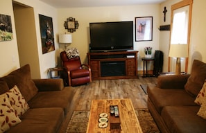 Living room with plenty of seating and large TV with cable and DVD player