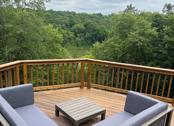 Enjoy the spacious deck with great lake views and cozy seating!  Picture during summer.