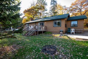 The lakeside facing the side of cabin depicting patio and firepit