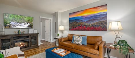 Living room with leather sofa, lots of natural light and fireplace.