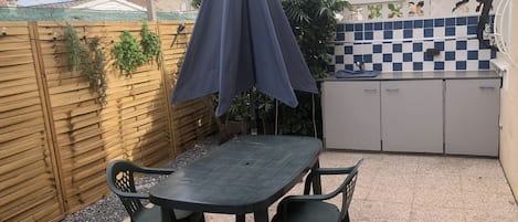 Terrasse aménagée avec sa table et ses 4 chaises et son parasol