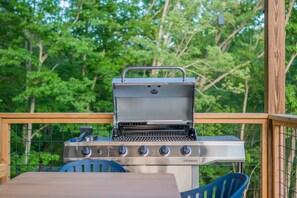 Upper porch has dining table and grill