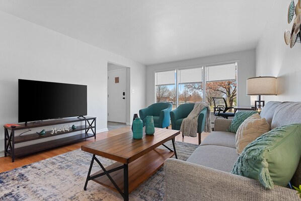 Spacious living room with smart TV and designated workspace.