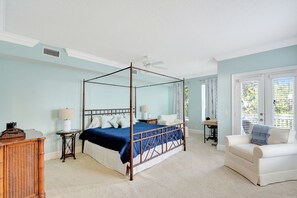 Primary Bedroom – King Bed, Balcony Access & Lounge Seating - Relax in a stately king suite with a four-poster bed, private balcony access, and lounge seating by the windows. This tranquil bedroom sets the tone for slow mornings and restful nights on St. Simons Island.